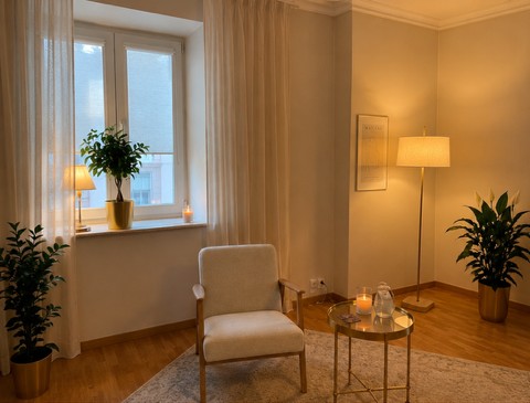 Przytulny gabinet psychoterapii z fotelem, oknem i lampą